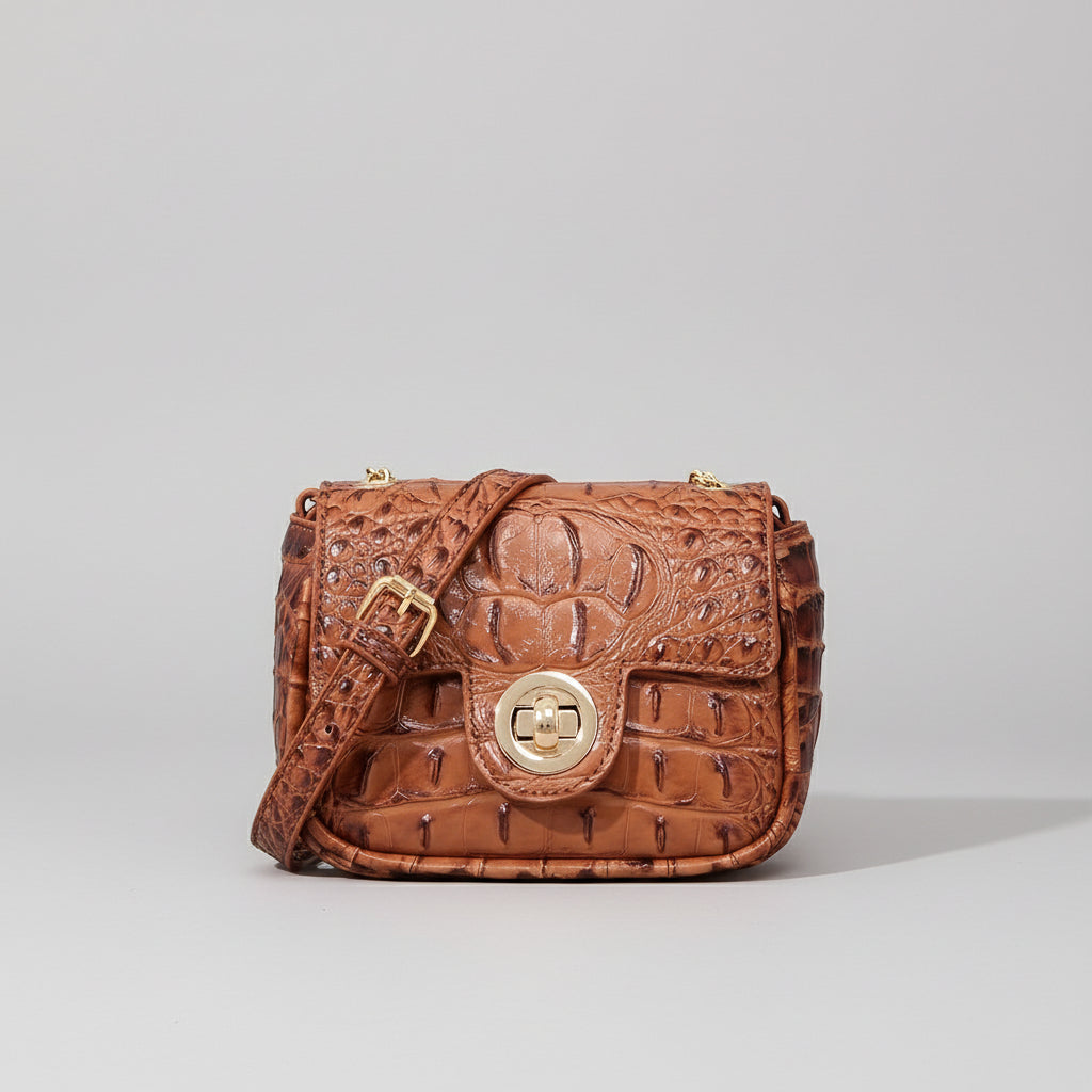 Brown textured handbag on a wooden surface with a dark background