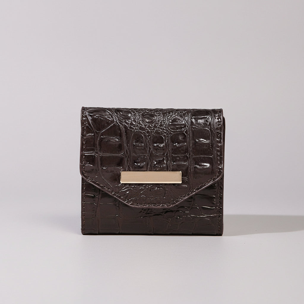 Black textured wallet with gold accent on a light surface and dark background