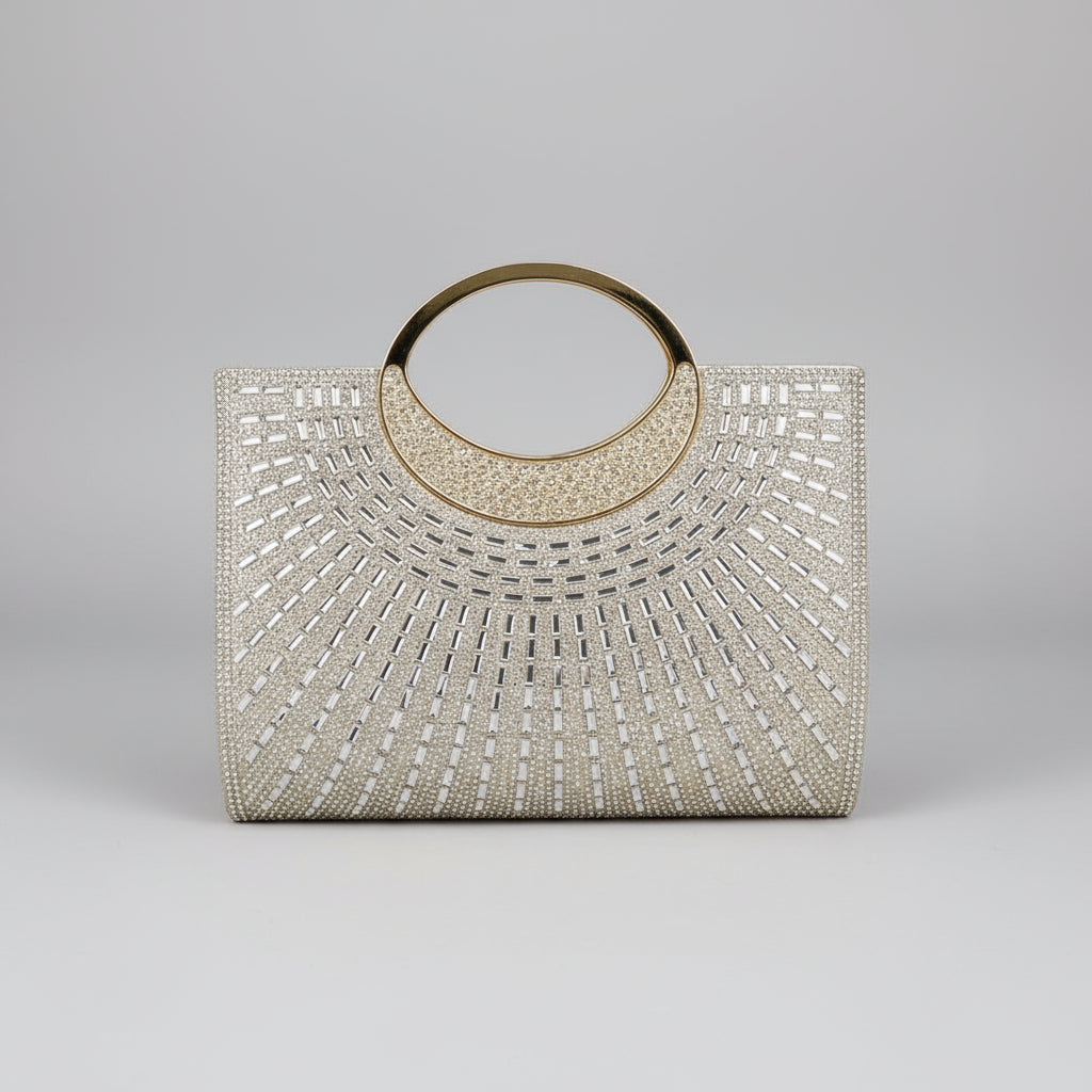 Elegant handbag with crystal embellishments held by a hand with red nail polish against a light blue background.