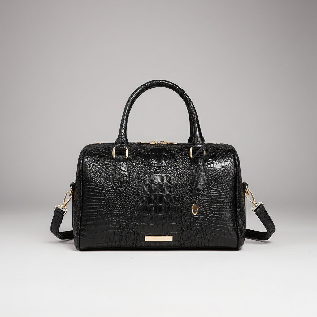 Black textured handbag on a light surface with a dark background